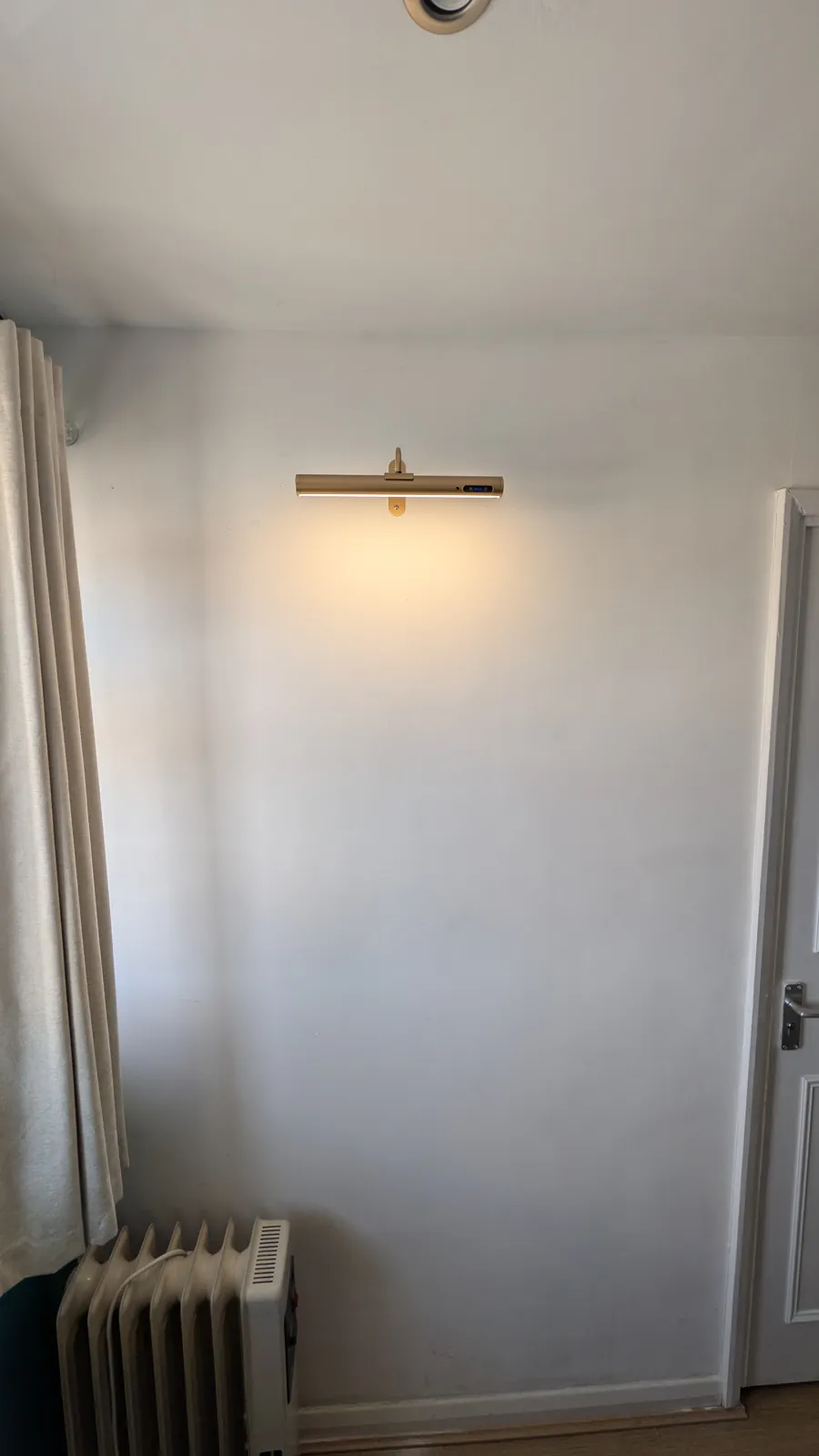 Brass picture light fitted on a bedroom wall