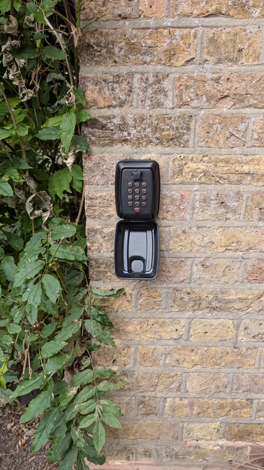 Key safe fitted to an exterior brick wall